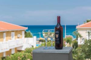 Anassa Hotel في سكالا كيفالونياس: زجاجة من النبيذ تجلس بجوار كأس من النبيذ