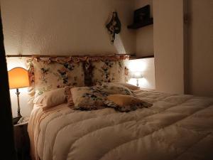 - une chambre avec un grand lit blanc et des oreillers dans l'établissement Ai piedi del Monte Bianco, à Entrèves