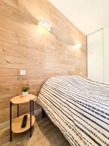 - une chambre avec un lit et un mur en bois dans l'établissement Élégante suite à deux pas de la Cité Épiscopale d'Albi, à Albi