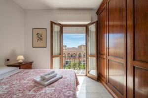 Un dormitorio con una cama y una ventana grande. en Dimoras Ampio Appartamento Centrocittà, en Olbia