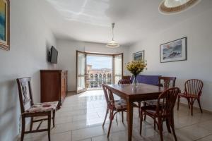 Un comedor con mesa y sillas de madera. en Dimoras Ampio Appartamento Centrocittà, en Olbia
