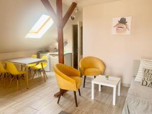 a living room with yellow chairs and a table at Lelle -kert Apartman 03 in Balatonlelle