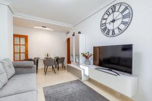 una sala de estar con un reloj grande en la pared en Espanatour BENIMAR en Cala de Finestrat