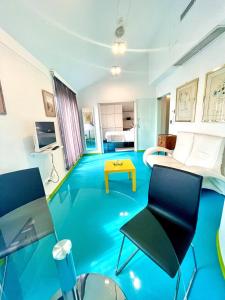 Zimmer mit blauem Boden, Stühlen und einem Tisch in der Unterkunft Domus Hotel in Luxemburg (Stadt)