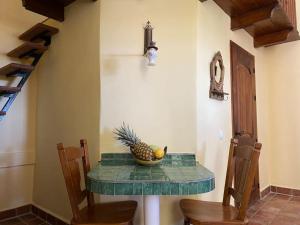 uma mesa com um ananás e uma taça de fruta em Castle Tower apartment in rural holiday park 'Bernard' em Tolox