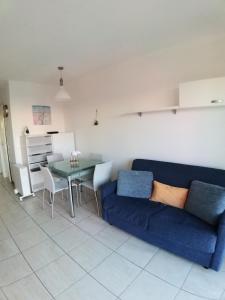 a living room with a blue couch and a table at Gabriella in Menton