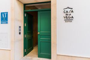 zielone drzwi w budynku z znakiem w obiekcie CASA DE LA VEGA SUITES w mieście Chiclana de la Frontera