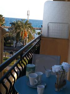 a table on a balcony with a view of the ocean at Gabriella in Menton