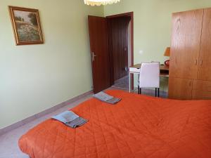 1 dormitorio con 1 cama grande de color naranja y 2 toallas en Family apartments "Hamster" up to 7 persons, en Zgornja Polskava