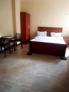 a bedroom with a large bed and a table and chairs at GSF Guest House in Addis Ababa
