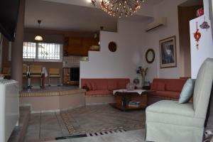 sala de estar con sofás rojos y cocina en Prosili, en Aiándion