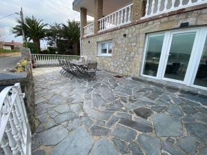 a patio with a table and chairs in front of a house at Casa del Muelle COMILLAS in Comillas +35 photos