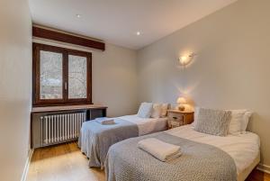 um quarto com 2 camas e uma janela em APARTMENT PRESIDENT - Alpes Travel - Central Chamonix - Sleeps 12 em Chamonix-Mont-Blanc
