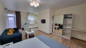 a living room with a blue couch and a mirror at GG ApartHotel in Batumi