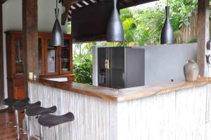 een keuken met een bar met zwarte krukken bij The Radian Villa in Canggu