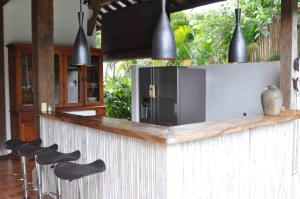 una cucina con bancone e sgabelli neri di The Radian Villa a Canggu