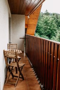 a porch with two wooden chairs and a table at Apartmány pod Kněhyní - BESKYDY in Horní Bečva