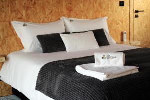 1 cama con sábanas blancas y almohadas blancas y negras en CÔA HONEYCOMB, en Pinhel