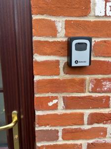 a toaster on a brick wall next to a door at The Old Stables in Mews in Kessingland