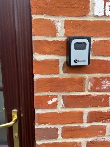 a toaster on a brick wall next to a door at The Old Stables in Mews in Kessingland