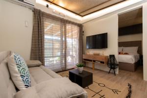 sala de estar con sofá y cama en Junam Private Beachfront Cabins, en Agios Nikitas
