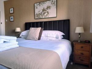 a bedroom with a large bed with a black headboard at Thurlestone House in St Ives