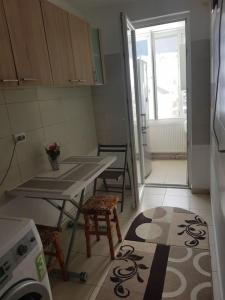 eine Küche mit Tisch und Stühlen und einem Herd in der Unterkunft Garsoniera Emilia in Câmpulung Moldovenesc