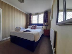 a bedroom with a large bed and two windows at Thurlestone House in St Ives