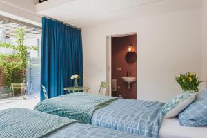 una camera con un letto blu e una finestra di Het Oplaadpunt bed, bike, hike, 4-8 p a Diksmuide