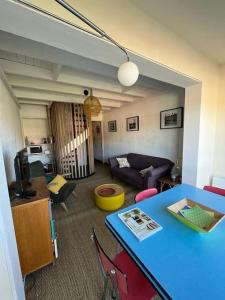 - un salon avec une table bleue et un canapé dans l'établissement L'Ibis Duplex proche plage et commodités, à Saint-Mandrier-sur-Mer
