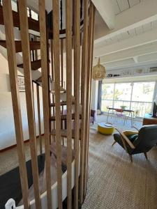 un salon avec un escalier en bois et une table dans l'établissement L'Ibis Duplex proche plage et commodités, à Saint-Mandrier-sur-Mer
