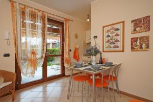 ein Esszimmer mit einem Tisch und orangefarbenen Stühlen in der Unterkunft Messaga in Toscolano-Maderno