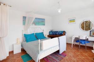 a bedroom with a white bed with blue pillows at Finca Fani 2 in Agüimes