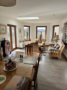 a living room with a table and a man laying on a couch at Doura Lodge in Inverness