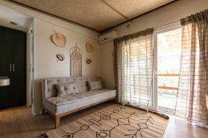 sala de estar con sofá y ventana en Junam Private Beachfront Cabins, en Agios Nikitas