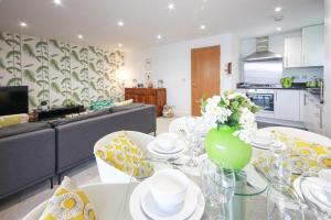 a living room with a table with a vase of flowers at Howells Mere 88, Tranquility P in Somerford Keynes