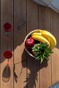 a bowl of fruits and vegetables on a wooden table at Junam Private Beachfront Cabins in Agios Nikitas