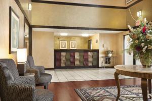 um lobby de um hotel com cadeiras e uma mesa em Super 8 by Wyndham Milwaukee Airport em Milwaukee