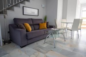 een woonkamer met een paarse bank en een tafel bij CasaDelSol-Marbella-Słońce,piasek,szmaragdowa woda in Marbella