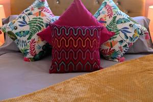 a group of pillows sitting on top of a bed at Charles Alexander Short Stay - Botanical House in Cleveleys