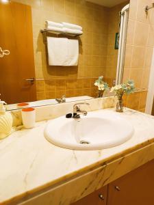 łazienka z białą umywalką i lustrem w obiekcie Duplex Playa de Rons w mieście O Grove +37 zdjęć