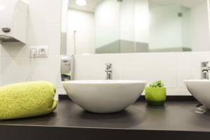 La salle de bains est pourvue d'un lavabo blanc et d'un miroir. dans l'établissement Downtown River Hostel, à Saint-Sébastien