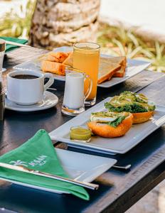 una mesa con platos de comida y una taza de café en Josan Villa with a Glorious Beach and Sea View en Habaraduwa Central