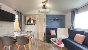 salon z niebieską kanapą i stołem w obiekcie L'incontournable Tout Confort Camping Siblu w Fréjus