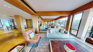 a living room filled with furniture and windows at Radisson Hotel Shimla in Shimla