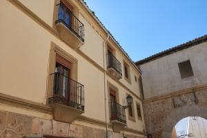 パストラナにあるCasona Alcarriaのバルコニー付きの建物とアーチのある建物