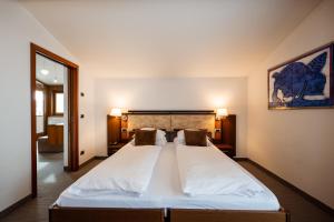 ein Schlafzimmer mit einem großen weißen Bett in einem Zimmer in der Unterkunft Feldmilla Design Hotel in Sand in Taufers