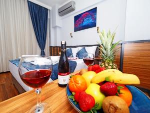 un tavolo con un piatto di frutta e una bottiglia di vino di Arges old city hotel a Istanbul