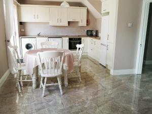 a kitchen with a table and chairs in a kitchen at Copper Coast Hideaway in Tramore