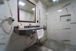 Belcehan Hotel في أولدينيس: حمام مع حوض ومرآة ودش